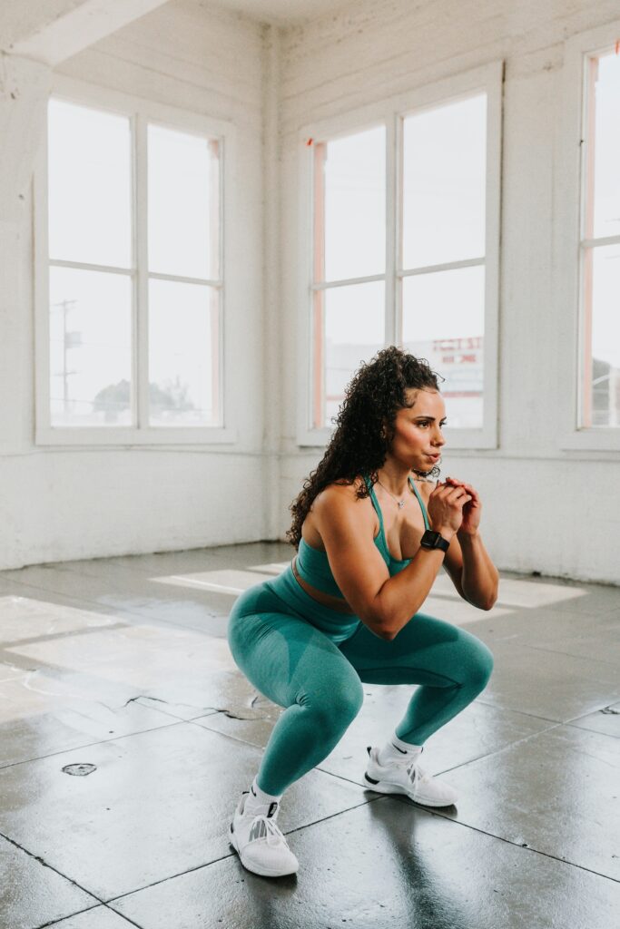 Woman doing squats in green sportswear