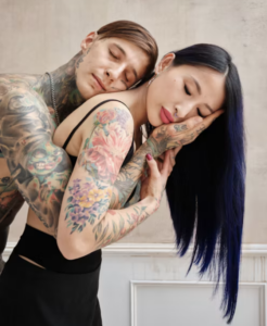 Couple tatoué enlacé, yeux fermés, dans un intérieur élégant