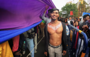 Participant souriant sous un drapeau violet lors d’une marche