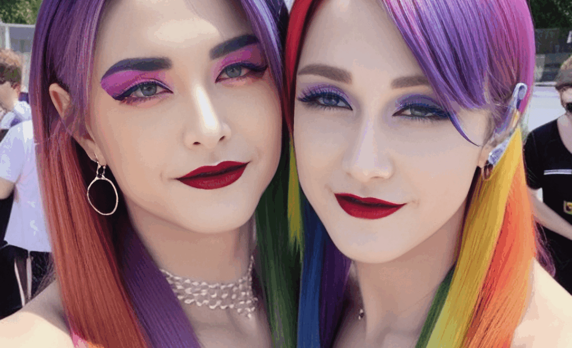 Deux femmes aux cheveux multicolores posent en extérieur